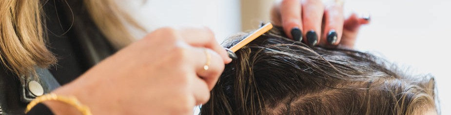 woman-stylist-cuts-hair-at-salon